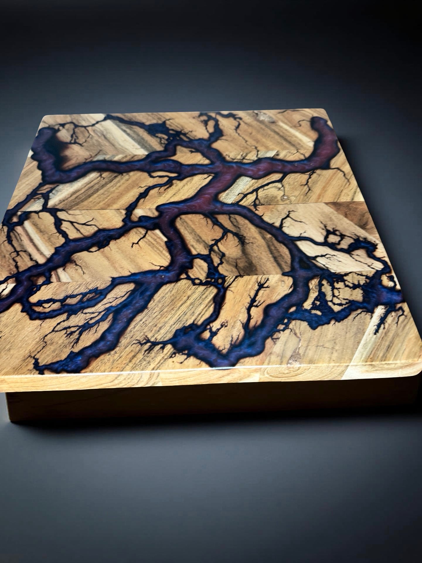 Square artisan timber board featuring red blue resin contrast with lightning style fractal burning accents handmade in Australia for grazing and serving setups