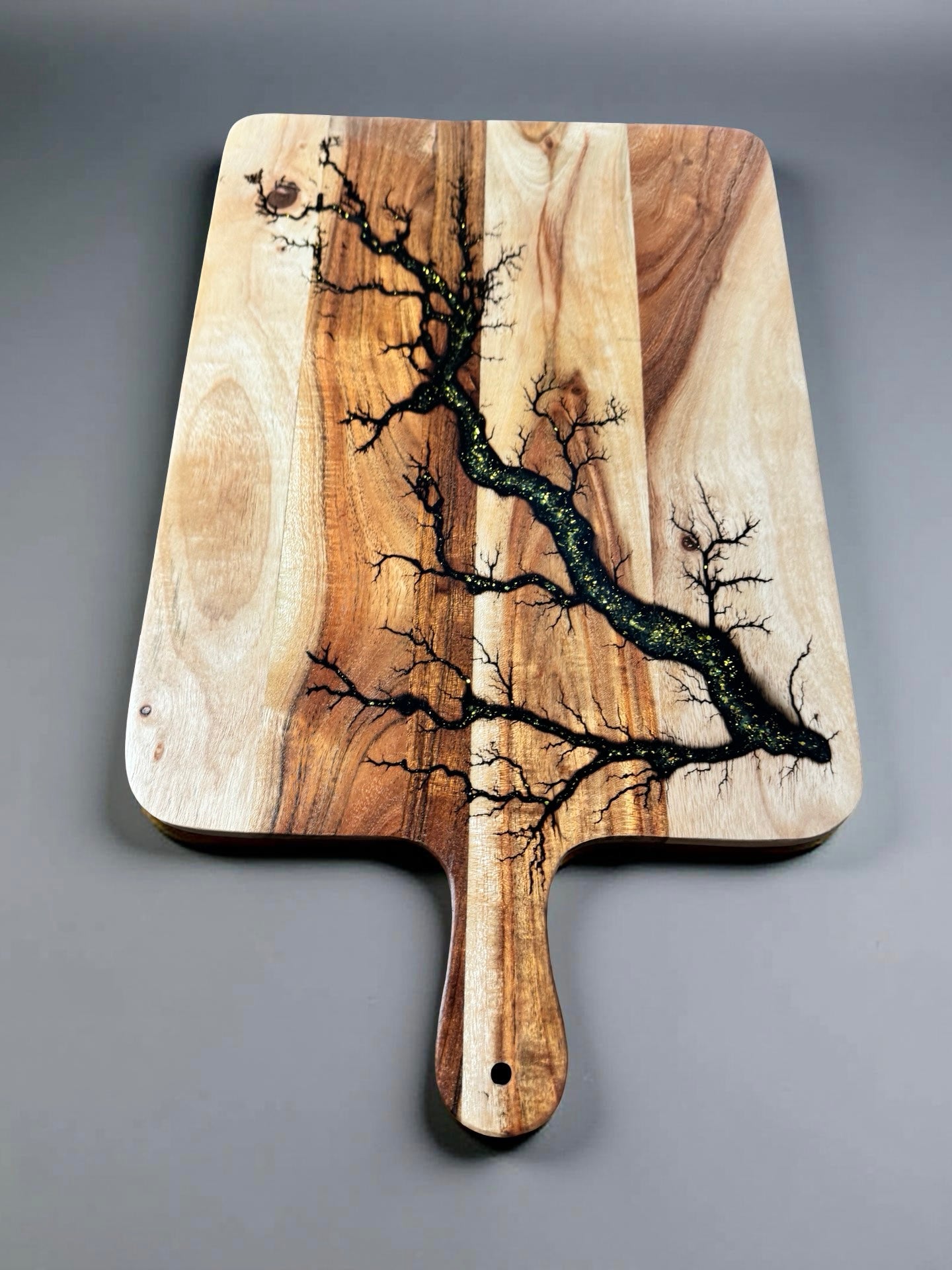 Australian made serving paddle board featuring radiant gold sparkle resin and sustainable timber