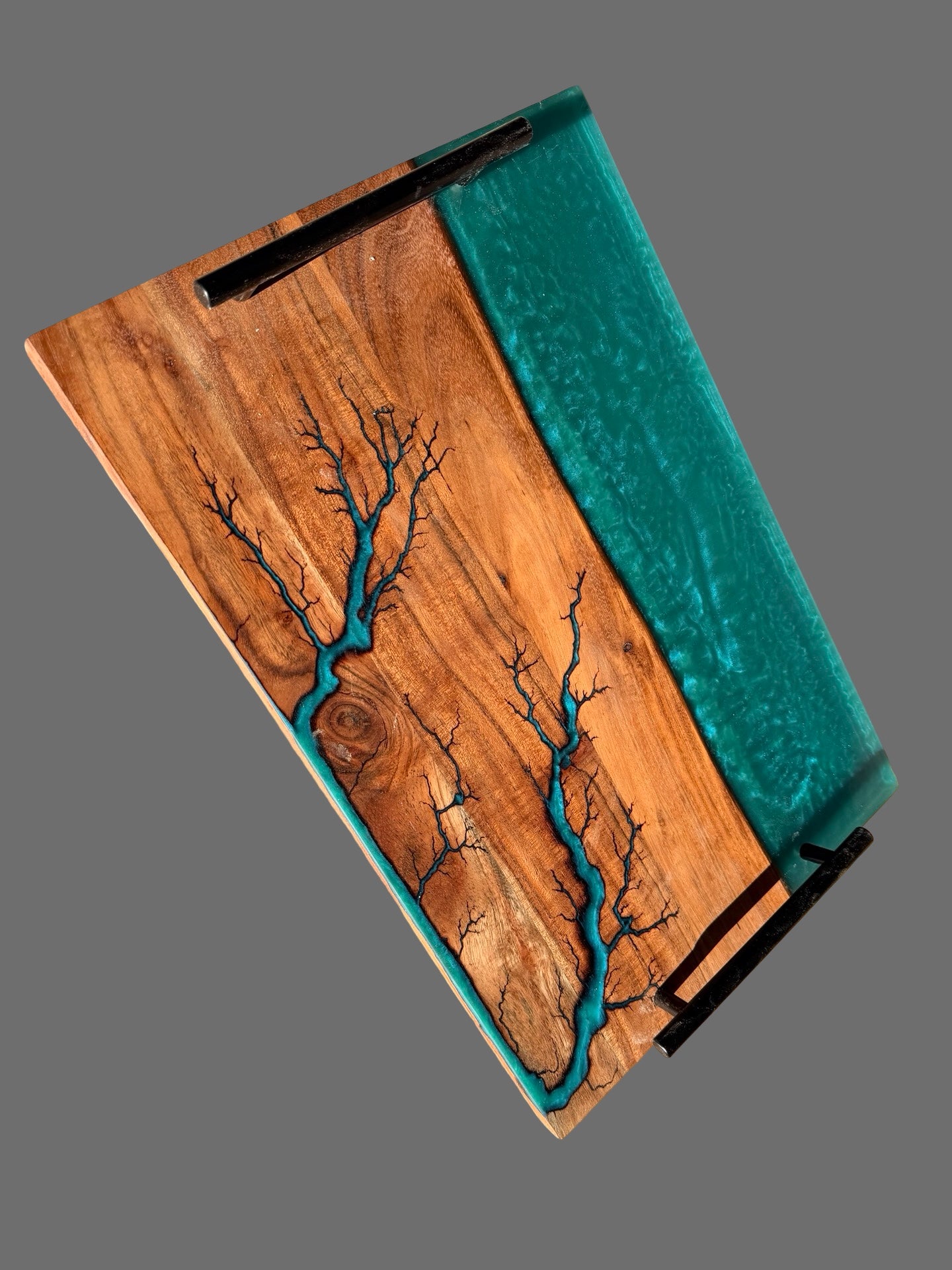 A rectangular resin board or tray with a natural wood grain surface, featuring a turquoise blue resin crack pattern resembling tree branches and a matching turquoise side panel, shown on a solid gray background.